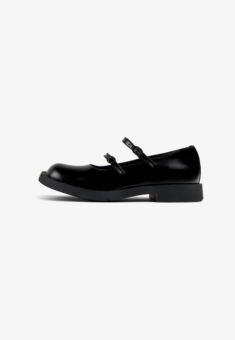 Black leather Mary Jane shoes with two adjustable straps, a rounded toe, and a low block heel. Smooth texture and minimalistic design.