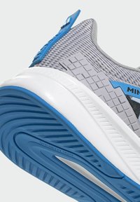 Scarpa sportiva con tomaia in mesh grigio, dettagli blu, pannello laterale in gomma grigia testurizzata e suola bianca e blu zigrinata con scritta "non marking".