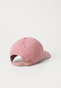 Casquette en coton rose avec une visière incurvée, une sangle ajustable et un détail en métal à l'arrière. Texture lisse et design à six panneaux.