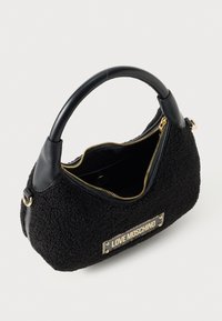 Melna teksturēta Love Moschino rokassoma ar noapaļotu rokturi un zelta rāvējslēdzēju, kas daļēji atvērts, atklājot iekšējo telpu.