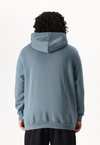 Blue hoodie with cuffed sleeves and a kangaroo pocket; features a drawstring hood and a soft, smooth texture.