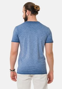 Blaues kurzes T-Shirt aus leichtem Stoff, mit melierter Textur, Rundhalsausschnitt und lockerer Passform.