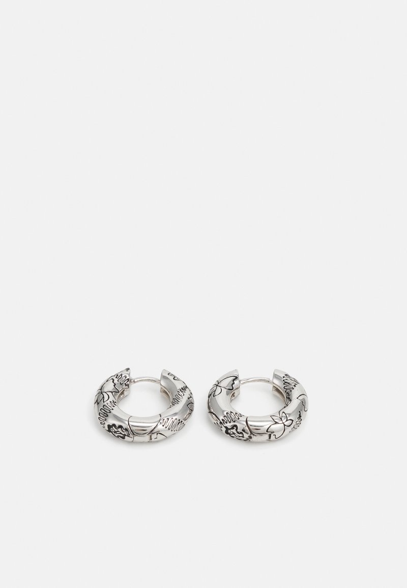 Boucles d'oreilles en argent en forme de créoles avec des motifs floraux gravés, présentant une finition lisse et polie ainsi qu'un design arrondi. Minimalistes et légères.