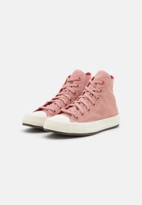 Pair of pink high-top canvas sneakers with white rubber soles and laces, displayed on a plain light gray background.