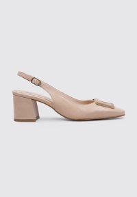 Zapato estilo slingback en beige con detalle de lazo texturizado. Presenta una puntera cuadrada y un tacón bloque moderado para un soporte estable. Acabado en piel suave.