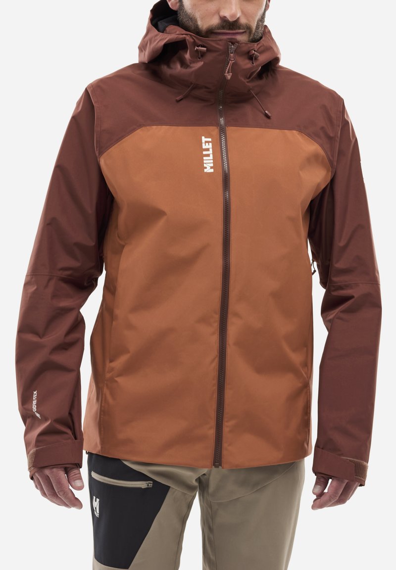Brown and rust-colored waterproof jacket with a hood, full zipper, and logo detail; smooth, lightweight fabric with adjustable cuffs.