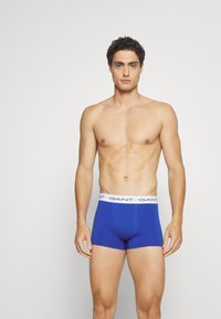 Blauwe katoenen boxershorts met een witte elastische tailleband met "GANT" merknaam, nauwsluitend ontwerp en lengte tot halverwege de dij.