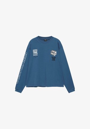 T-shirt bleu à manches longues avec col rond, imprimé de textes blancs et noirs sur la poitrine et la manche droite, incluant les phrases « Seriously, enjoy more THINK » et « STWD GOODS ».
