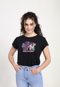 Zwart katoenen T-shirt met een grafisch ontwerp dat een paarse en groene vierkant patroon en de tekst "MTV Music Television" toont. Korte mouwen.