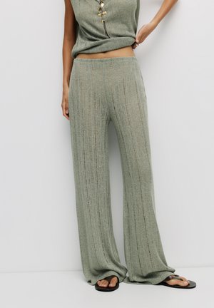 Pantalons larges en maille côtelée verte avec une texture douce. Assortis d'un haut correspondant, doté de quincaillerie décorative et d'une coupe décontractée.