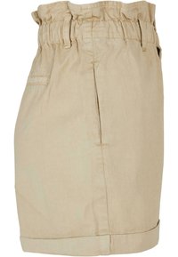 Shorts beiges taille haute avec ceinture élastique, passants pour ceinture, poches latérales et ourlet replié, vus de côté.