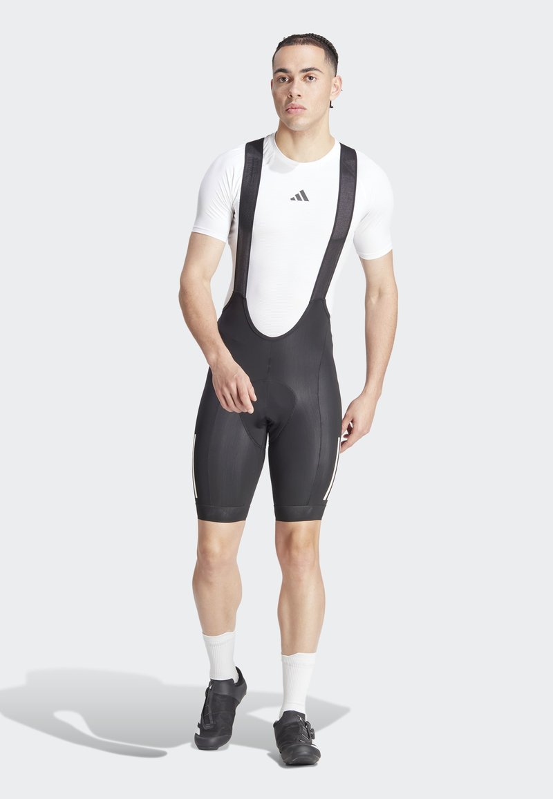 Pantaloni da ciclismo neri con bretelle regolabili, dotati di fondello imbottito, strisce riflettenti e vestibilità aderente sulle gambe.