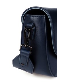 Námořnická modrá kožená taška s černými detaily, obsahující klip a prošívané akcenty. Hladký povrch s kulatým klopou.