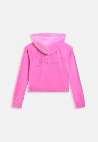 Jachetă cu glugă din velur roz aprins, cu mâneci lungi și textul „Juicy” scris cu strasuri pe partea superioară a spatelui.