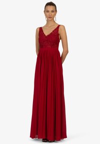 Langes rotes Kleid mit V-Ausschnitt, Spitzenoberteil und plissiertem Rock. Verfügt über schmale Träger und eine taillierte Passform. Glatte Stofftextur.