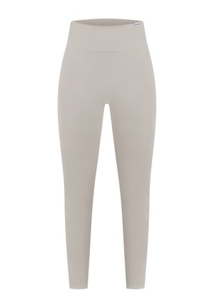 Leggings beiges en matériau lisse et extensible. Taille haute sans coutures visibles. Design ajusté, se rétrécissant aux chevilles.