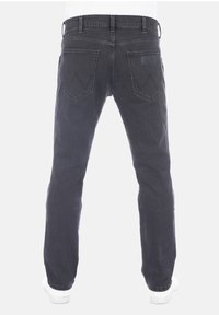 Černé džíny z denimu s úzkým střihem, vybavené dvěma zadními kapsami, koženou značkovou záplatou a jemnými švovými detaily podél švů.