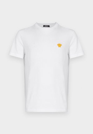T-shirt en coton blanc à manches courtes, avec un petit logo jaune brodé sur la poitrine gauche. Design classique à col rond.