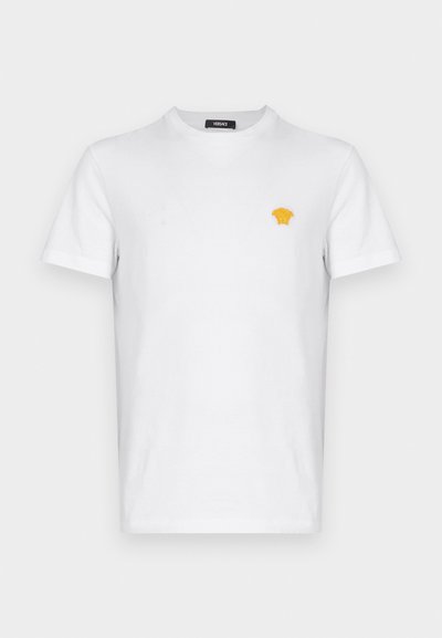 T-shirt de algodão branco com mangas curtas, apresentando um pequeno logótipo amarelo bordado no lado esquerdo do peito. Design clássico de decote redondo.