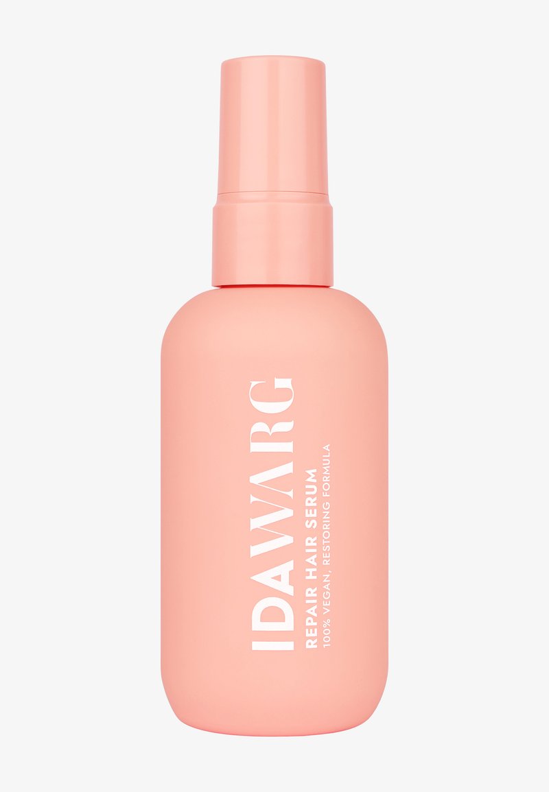Rosa plastflaska med IDAWARG Repair Hair Serum, utrustad med spraymunstycke och vit text som beskriver dess 100 % veganska och återställande formula.