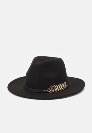 Chapeau fedora noir à large bord avec un ruban noir fin et un détail décoratif de feuille de fougère dorée sur le côté.