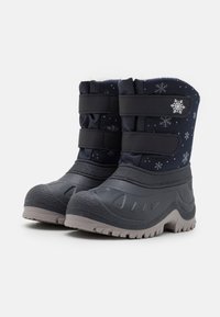 Bottes de neige navy avec une doublure intérieure douce, semelles en caoutchouc noir texturé et sangles en Velcro grises. Décorées de motifs de flocons de neige blancs.