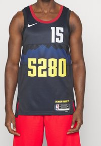Maglia da basket Nike nera con colletto rosso, numeri gialli "5280" e "15", design della montagna blu, con "DENVER NUGGETS" sull'orlo.