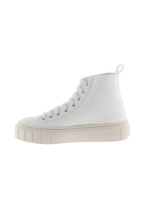 Sneaker alta bianca in tela con una spessa suola in gomma beige, occhielli prominenti e una linguetta sul retro per facilitare l'indossamento.