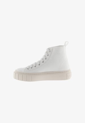 Hoge witte canvas sneaker met een dikke beige rubberen zool, opvallende oogjes en een flap aan de achterkant voor gemakkelijk aan- en uittrekken.