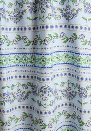 Svetlomodrá látka obsahuje kvetinové vzory v odtieňoch modrej a zelenej, s horizontálnymi pruhmi a zložitými detailami po celom povrchu.