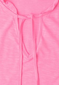 Close-up of a pink knit top with a round neckline featuring a keyhole opening and a narrow fabric tie at the center.