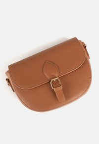 Sac bandoulière en cuir marron avec rabat arrondi, boucle dorée et sangle réglable sur fond blanc.