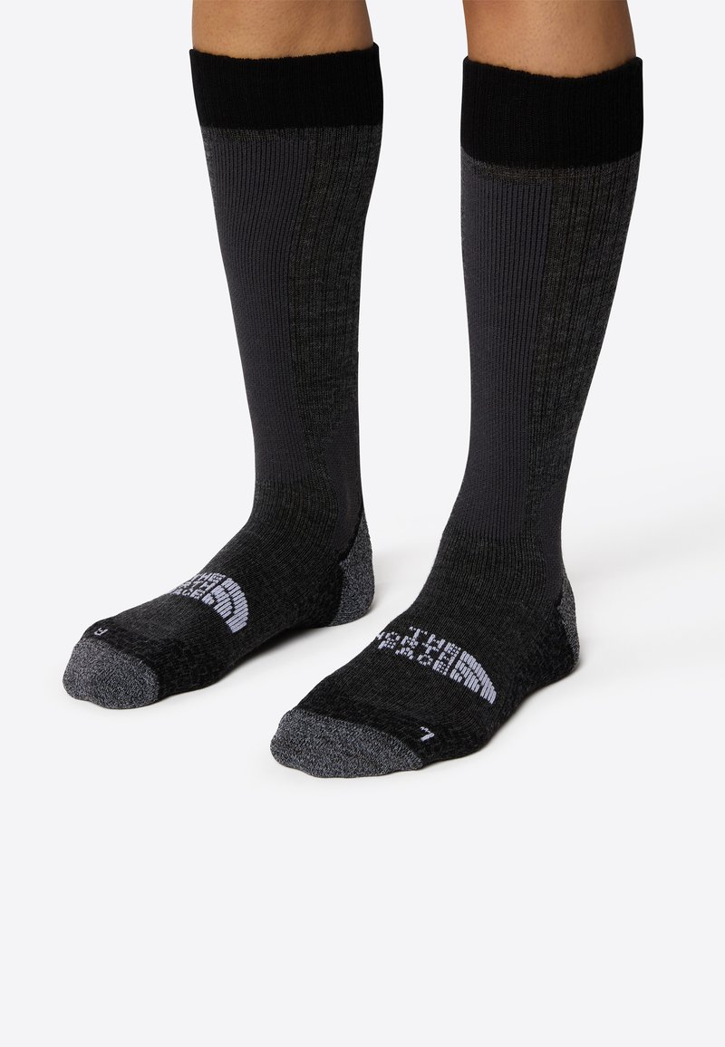Črne nogavice do kolen z rebrasto teksturo, ki imajo sivo dekoracijo in logotip North Face na prstu. Udobno prileganje.