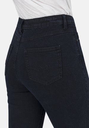 Dunkelblaue Jeans im figurbetonten Schnitt. Merkmale sind Gesäßtaschen und dezente Nähte. Weicher Stoff und strapazierfähiges Material.