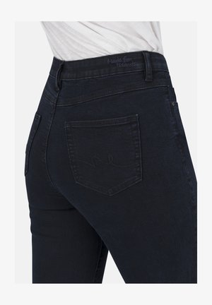 Dunkelblaue Jeans im figurbetonten Schnitt. Merkmale sind Gesäßtaschen und dezente Nähte. Weicher Stoff und strapazierfähiges Material.