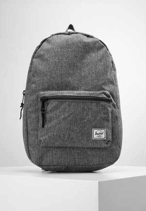 Zaino in tessuto grigio con finitura testurizzata, tasca anteriore con zip e etichetta del marchio sul frontale inferiore. Spallacci regolabili e forma arrotondata.