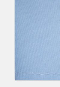 Lyseblå ribbet stoff med en glatt tekstur, med synlige sømmer langs kanten, som gir et tettsittende design og elastisitet.