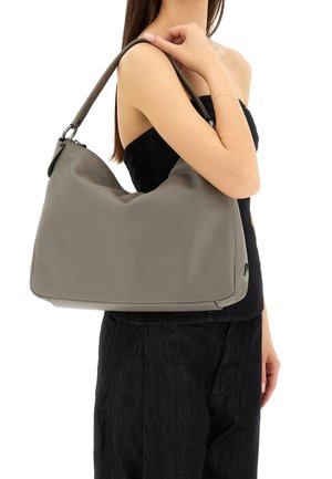 Borsa a tracolla in pelle grigia con una finitura morbida e testurizzata; presenta un design curvo e una tracolla, fissata con elementi metallici.