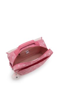 Borsa Kipling a motivo rosa con scomparto principale con zip aperto e un soffice portachiavi attaccato al cursore della zip.