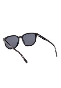 Gafas de sol negras en forma de ojo de gato con lentes oscuros, que cuentan con un marco brillante y patillas con un patrón de carey. Incluye detalles metálicos.