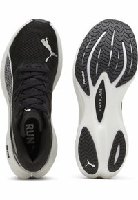 Zapatillas deportivas negras con parte superior de malla, logo reflectante y suela de goma flexible. Cuenta con una banda de rodadura texturizada y una mediasuela acolchada para mayor soporte.