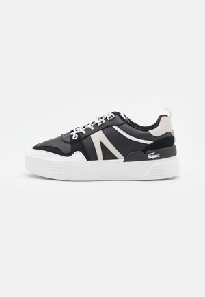 Czarno-białe niskie sneakersy z białymi sznurówkami, grubą białą podeszwą, zamszowymi elementami i małym logo krokodyla po stronie pięty.