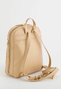 Sac à dos en simili cuir beige au design structuré, avec des accents en métal doré et des bretelles réglables, doté d'une fermeture éclair latérale pour un accès facile.