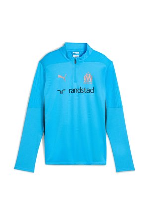 Lyseblå langærmet sportstrøje med kvart lynlås, Puma-logo, Olympique de Marseille-emblem og Randstad-sponsor foran.