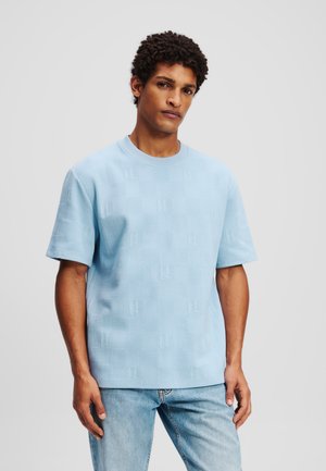 Tricou cu mânecă scurtă, de culoare albastru deschis, cu un model texturat și decolteu rotund, asortat cu blugi de culoare albastru deschis.