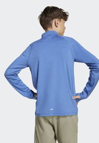 Dlhý rukáv modré športové tričko vyrobené z ľahkého materiálu s límcom, s hladkou textúrou a jemným brandingom na výstrihu.