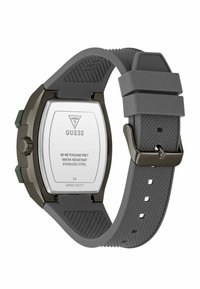 Montre avec bracelet en silicone gris et un boîtier en acier inoxydable, ornée d'accents verts, d'un cadran carré et d'une résistance à l'eau jusqu'à 50 mètres.