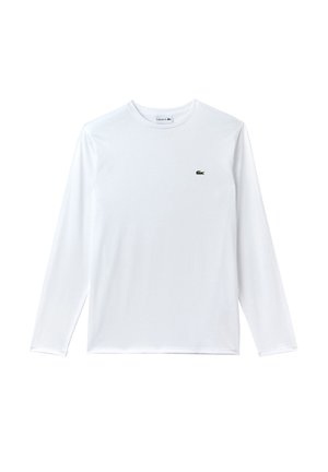 T-shirt bianco a maniche lunghe in cotone, con un piccolo logo verde Lacoste nella parte sinistra del petto. Texture liscia, scollatura rotonda.
