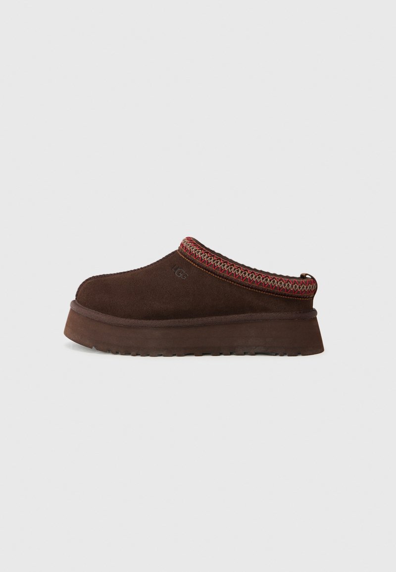 Chaussure en suède marron à enfiler avec une semelle en caoutchouc texturé, dotée d'un bord en tricot rouge et à motifs autour du col.