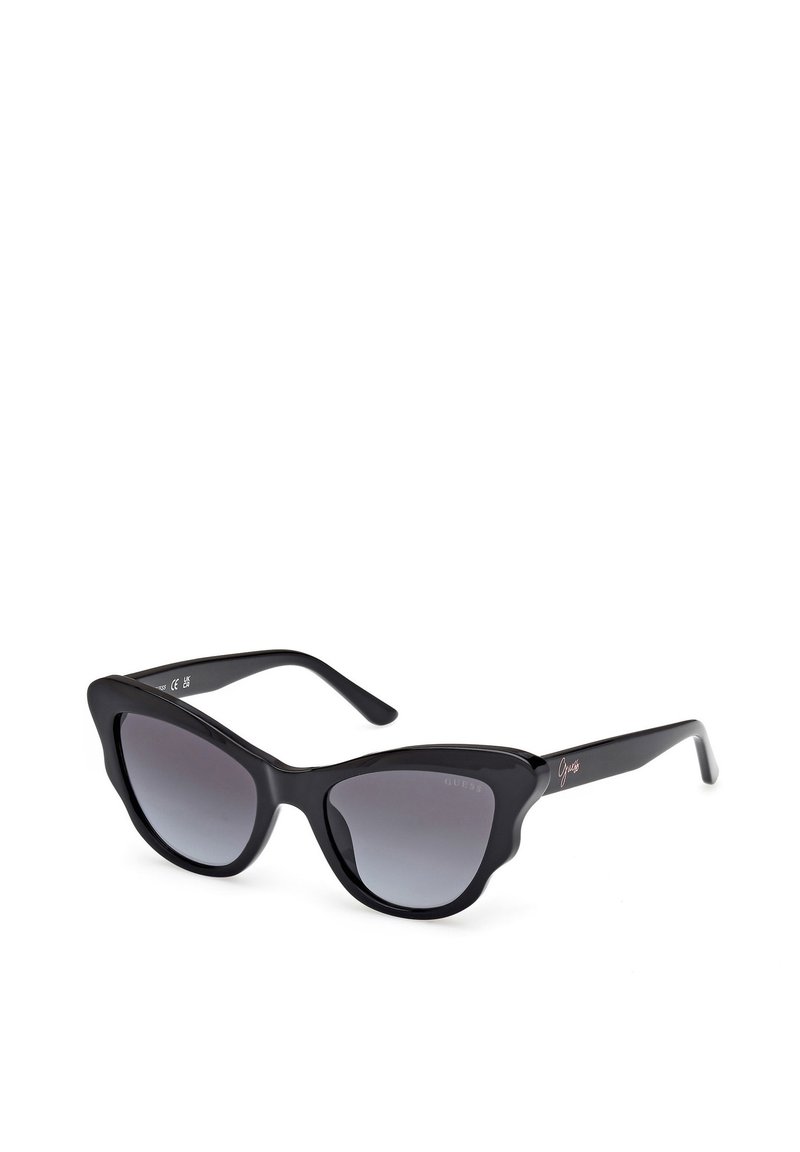 Gafas de sol estilo gato negro con lentes degradados. Hechas de plástico brillante, presentan montura gruesa, puntas afiladas y una sutil marca en las patillas.